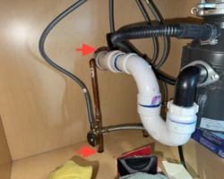 Under-Sink Pipe Penetrations – Left Unsealed Open gaps around supply and drain pipes entering the wall beneath a sink cabinet