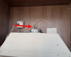 Range hood duct stub discharging into the underside of a kitchen wall cabinet