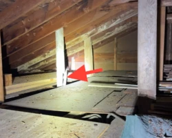 Vertical wood roof support post split along the grain near its bearing point