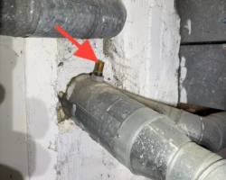 Furnace Vent – Unsealed Penetration at the Chimney Copper pipe stub protruding from a chimney opening beside furnace vent connectors