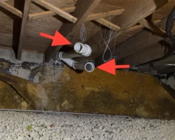 Disconnected PVC pipe with open ends discharging into a crawlspace